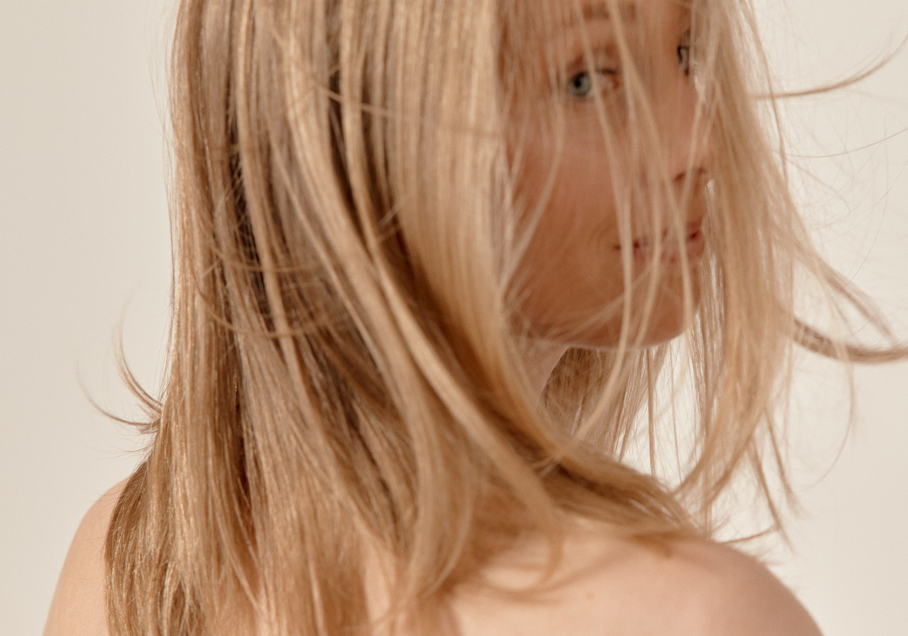 femme blonde qui se retourne avec les cheveux dans le vent