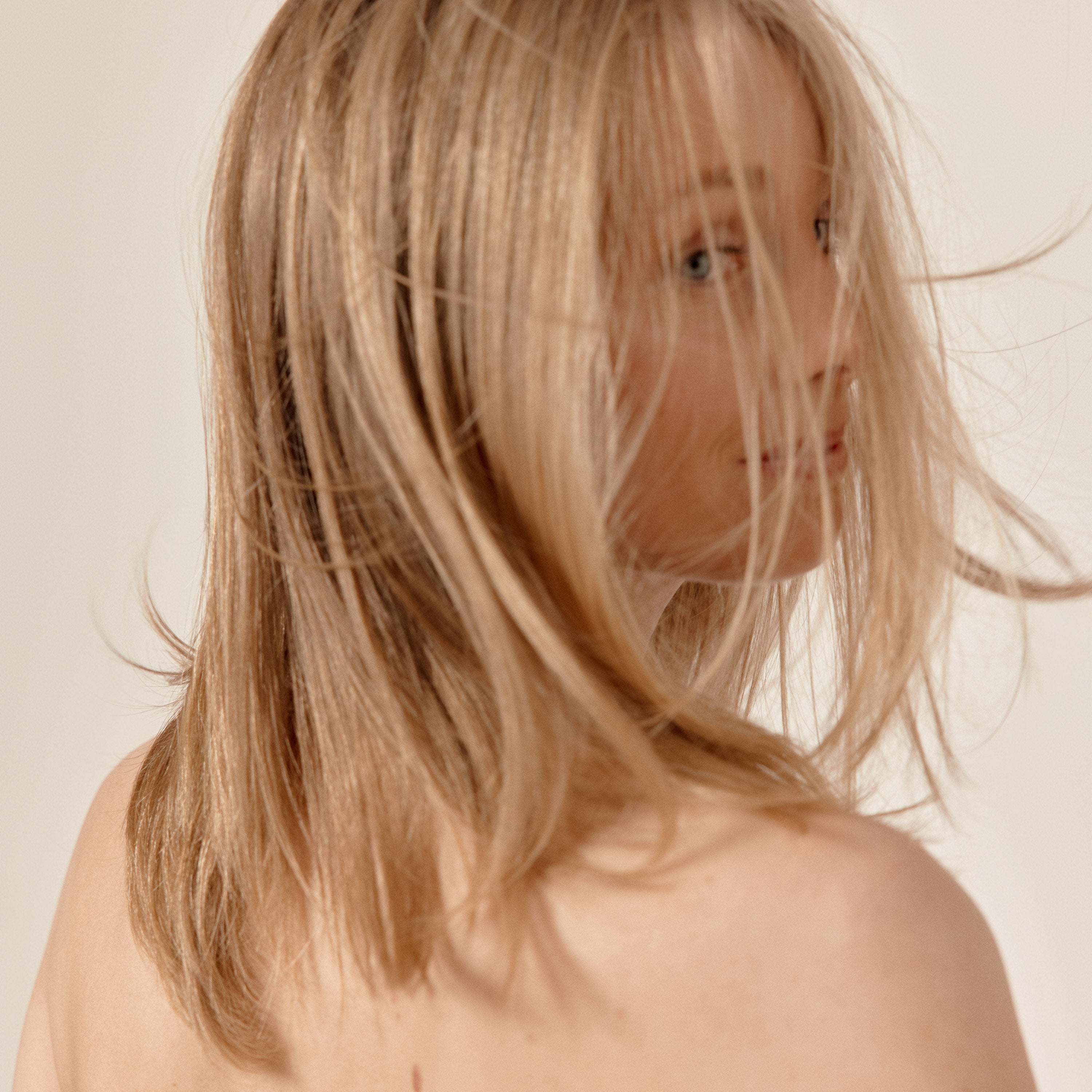 femme blonde qui se retourne avec les cheveux dans le vent