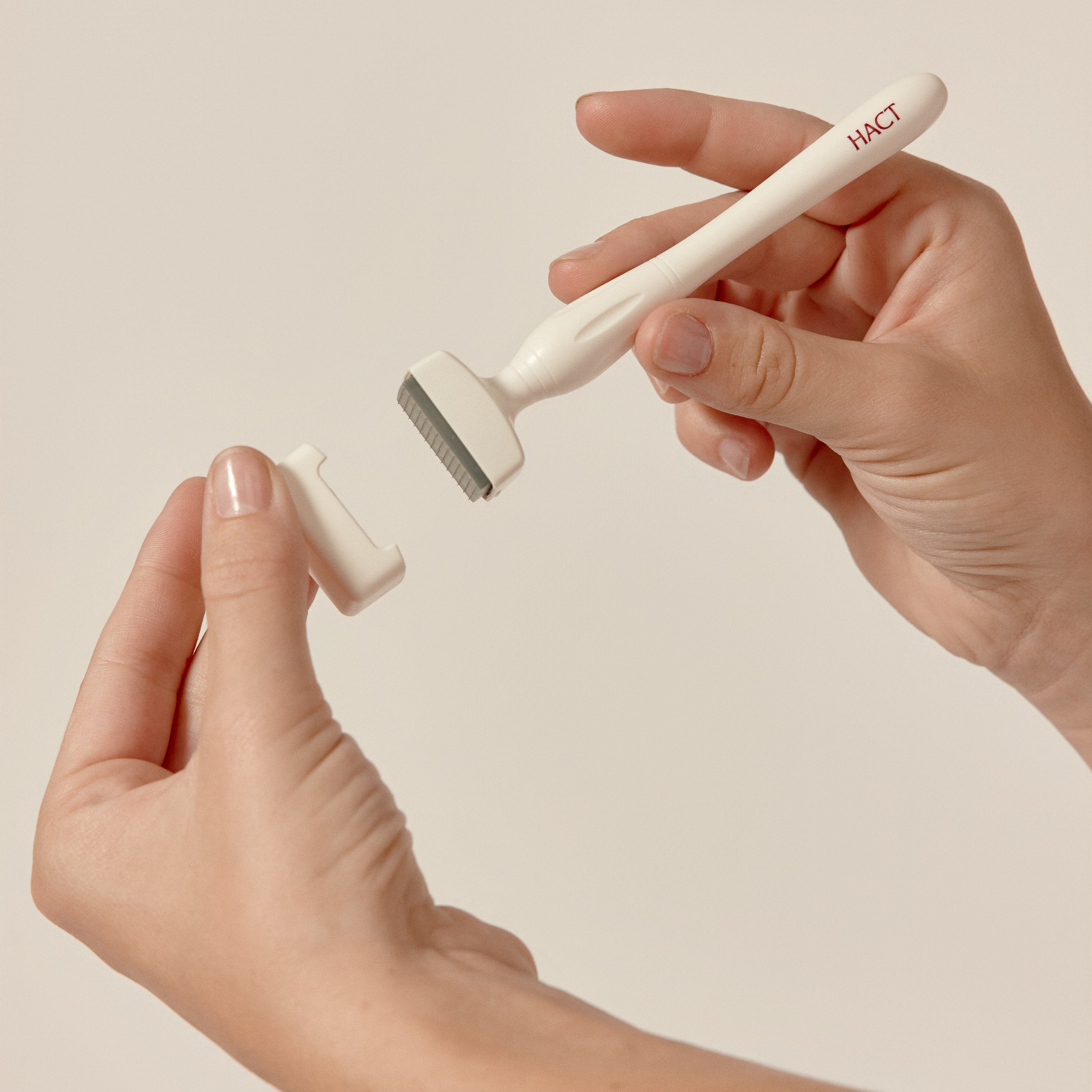 une main qui tient un dermastamp et son couvercle dans l'autre main 