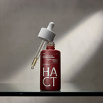 flacon rouge avec la pipette dehors sur un support en verre